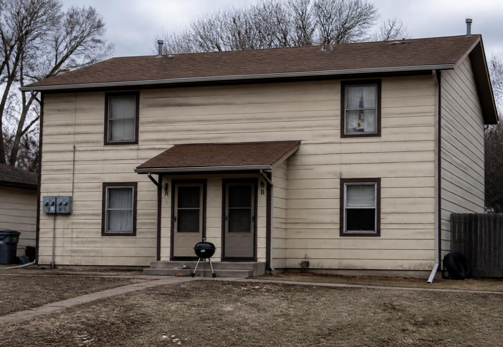 Tired rental duplex with worn siding